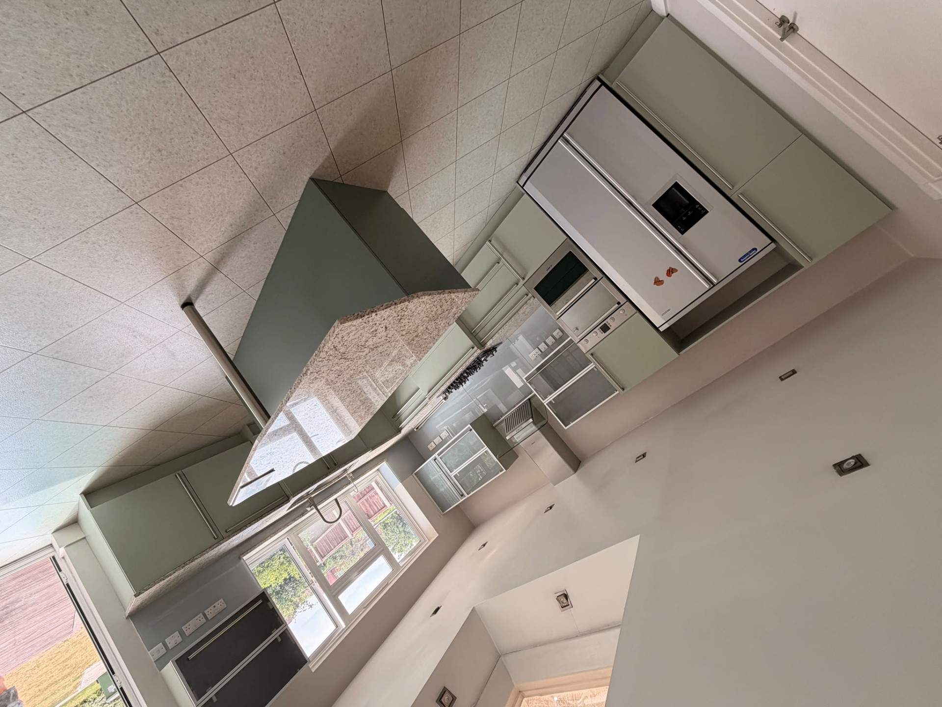 Sage green kitchen respray with island, granite worktops and integrated appliances
